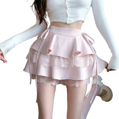 A woman wearing a pink knee-length skirt with lace details and ribbon ties at the waist, showcasing a whimsical and feminine style.