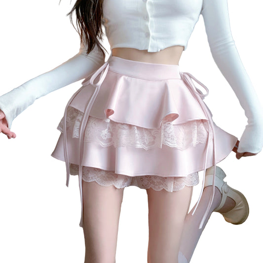 A woman wearing a pink knee-length skirt with lace details and ribbon ties at the waist, showcasing a whimsical and feminine style.
